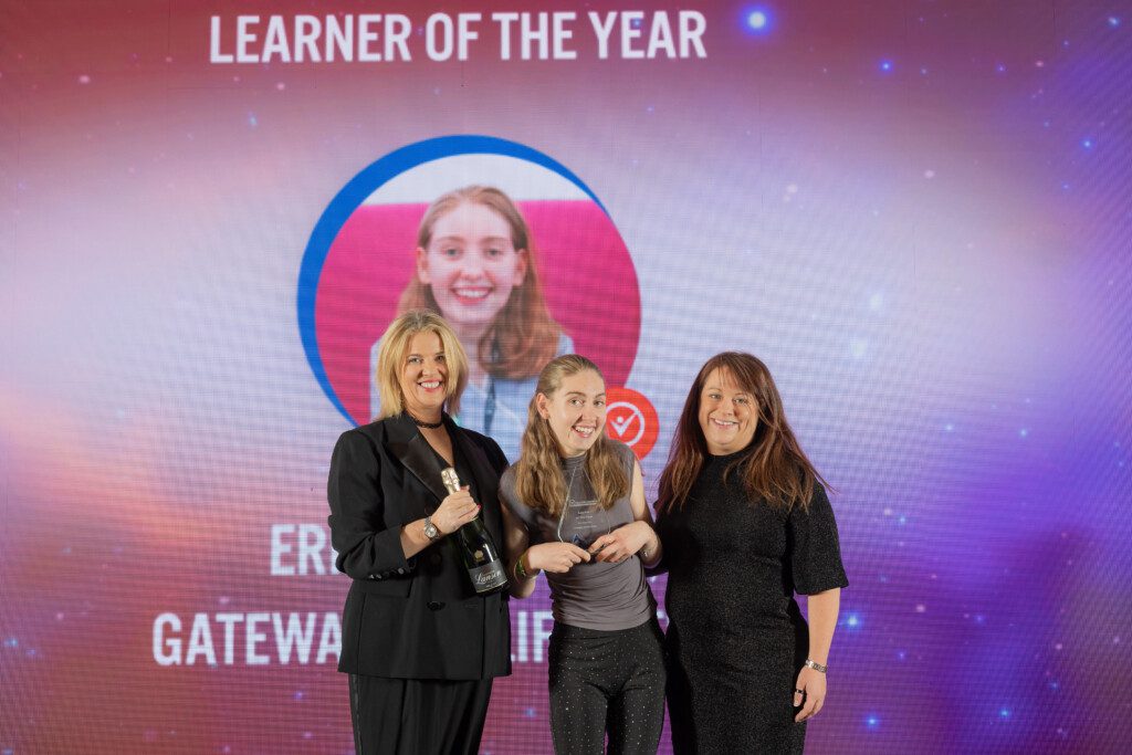 Group of three people on awards ceremony stage presenting the Learner of the Year Award