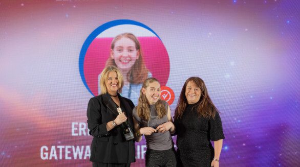 Group of three people on awards ceremony stage presenting the Learner of the Year Award